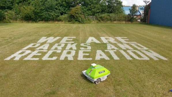 WE ARE PARKS AND RECREATION text. Painted on grass field by Turf Tank