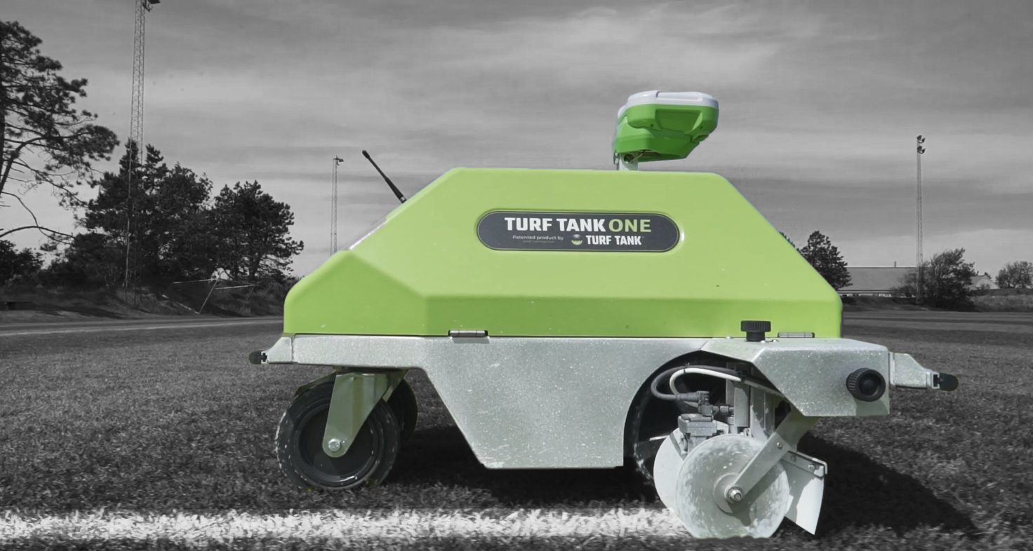 Picture from the side of a turf tank robot with the background being in black and white