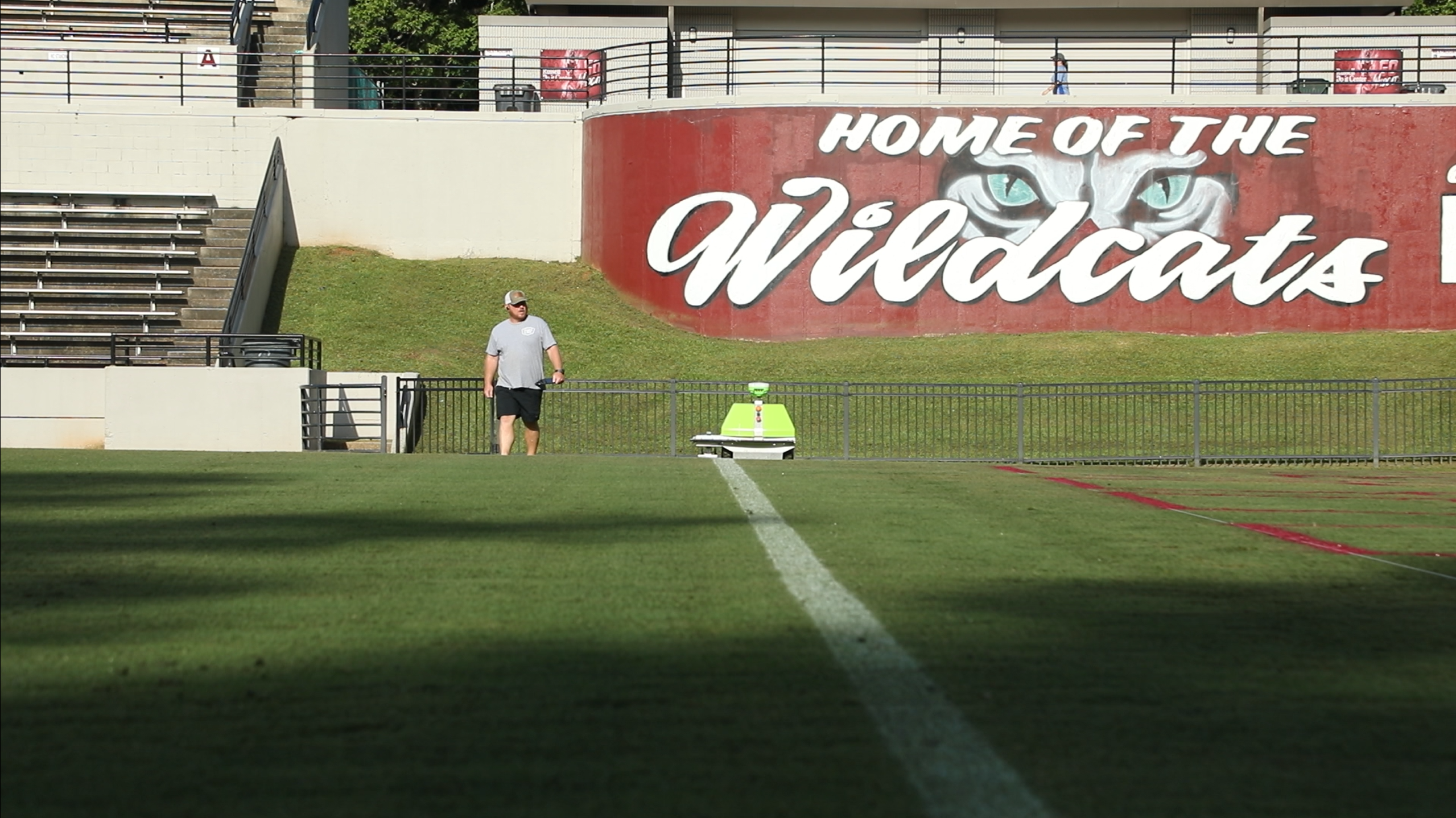 Turf Tank robot marking a field with a Wildcat logo in the background