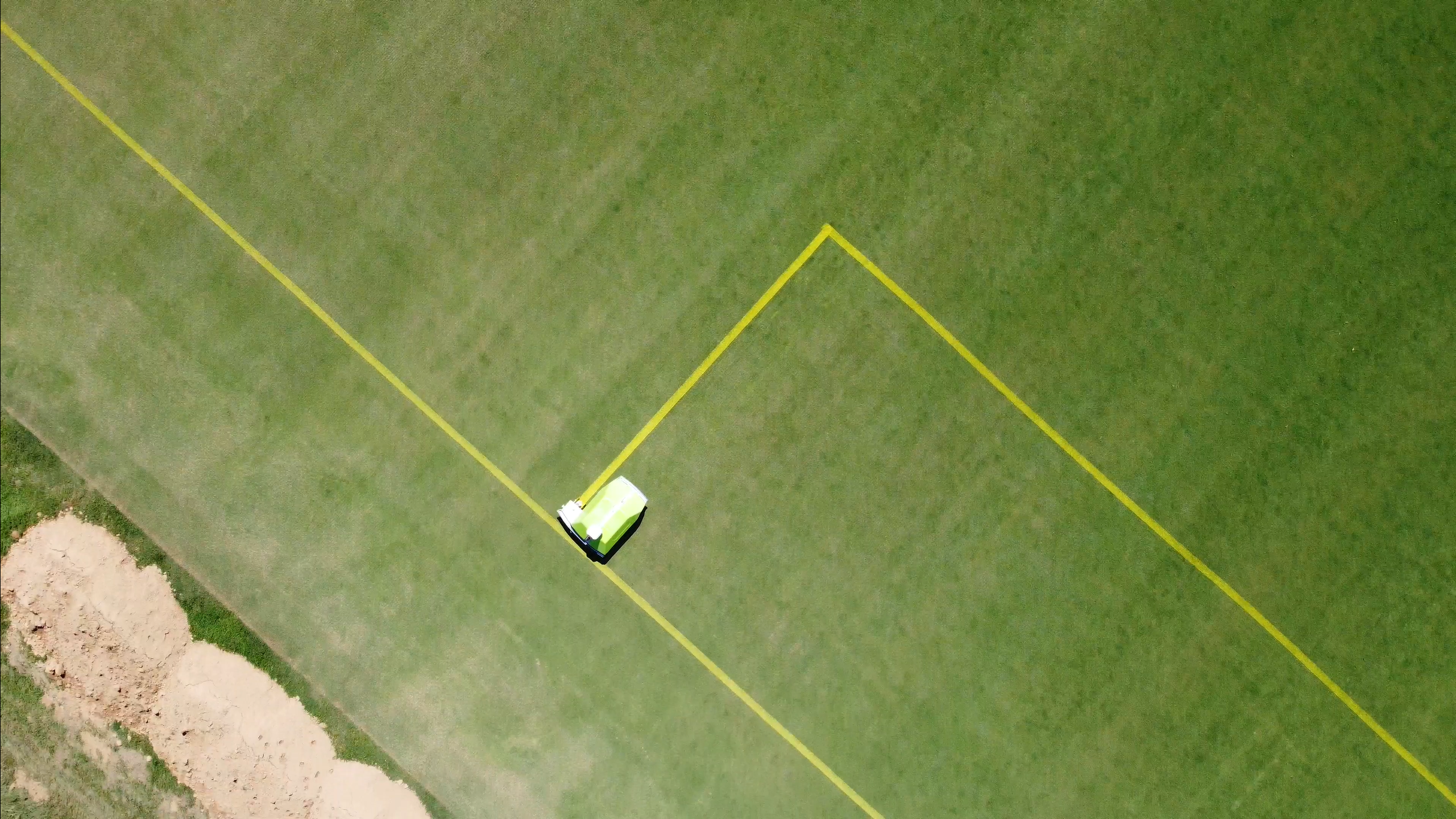 Turf tank robot painting a yellow penalty box on soccer field