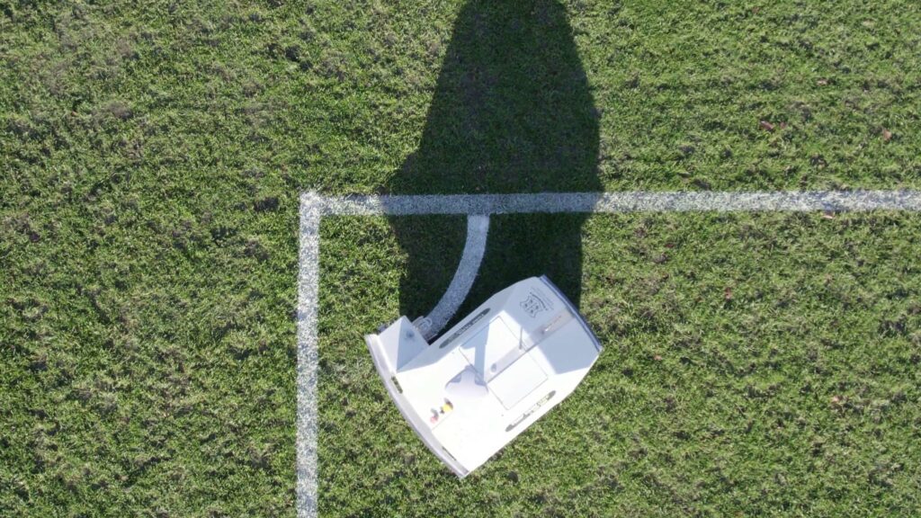 Workshop college's autonomous line marking robot painting corner arcs on a soccer field